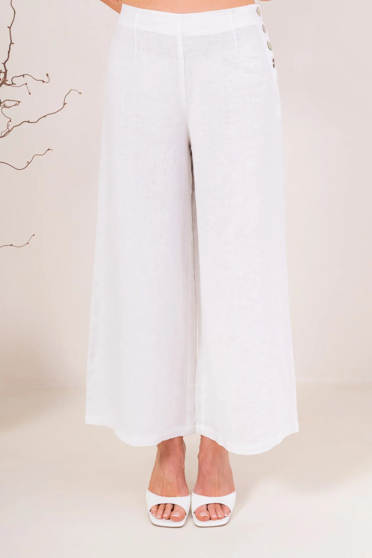 Palazzo linen pants featuring a relaxed wide-leg fit, high waist and shell button detailing down the side seam.