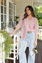 Boyfriend linen shirt in rhubarb stripe, designed with a relaxed fit, French seams, tab sleeves, and a flattering scoop hem. Crafted for comfort and effortless style.