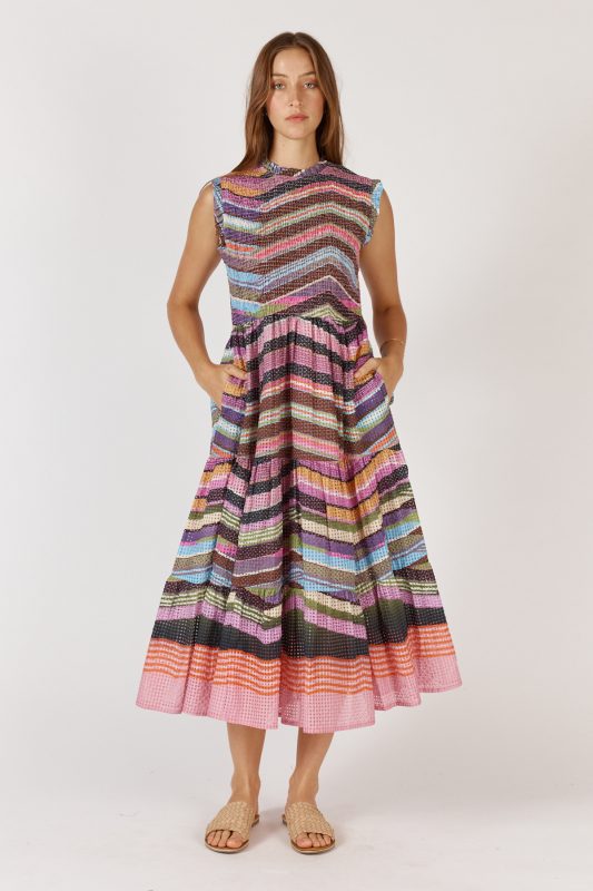 A flowing maxi dress made from a textured check-weave cotton-nylon blend, featuring a round neckline with delicate frill detailing and sleeveless armholes with matching frill trims. The shirred bodice offers a flattering, fitted shape, while the relaxed A-line skirt falls to mid-calf for an elegant, easy drape. Functional pockets add practicality to this feminine, effortless design
