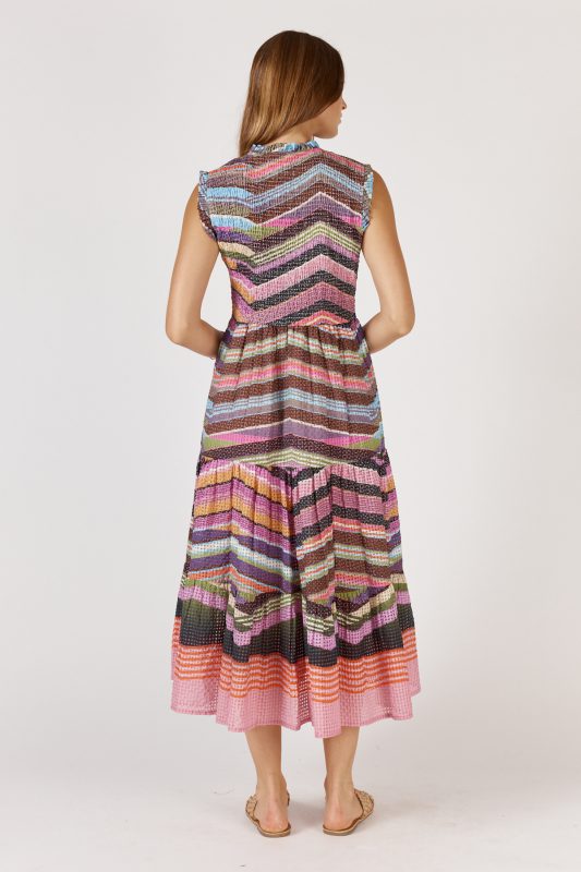 A flowing maxi dress made from a textured check-weave cotton-nylon blend, featuring a round neckline with delicate frill detailing and sleeveless armholes with matching frill trims. The shirred bodice offers a flattering, fitted shape, while the relaxed A-line skirt falls to mid-calf for an elegant, easy drape. Functional pockets add practicality to this feminine, effortless design
