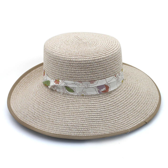 A stylish mix camel Flexibraid® hat featuring a reverse trilby-style brim, flat crown, beige contrasting ribbon edge, and a Liberty floral puggaree band. Offers UPF50+ sun protection and a ComfyFit adjuster for a perfect fit.