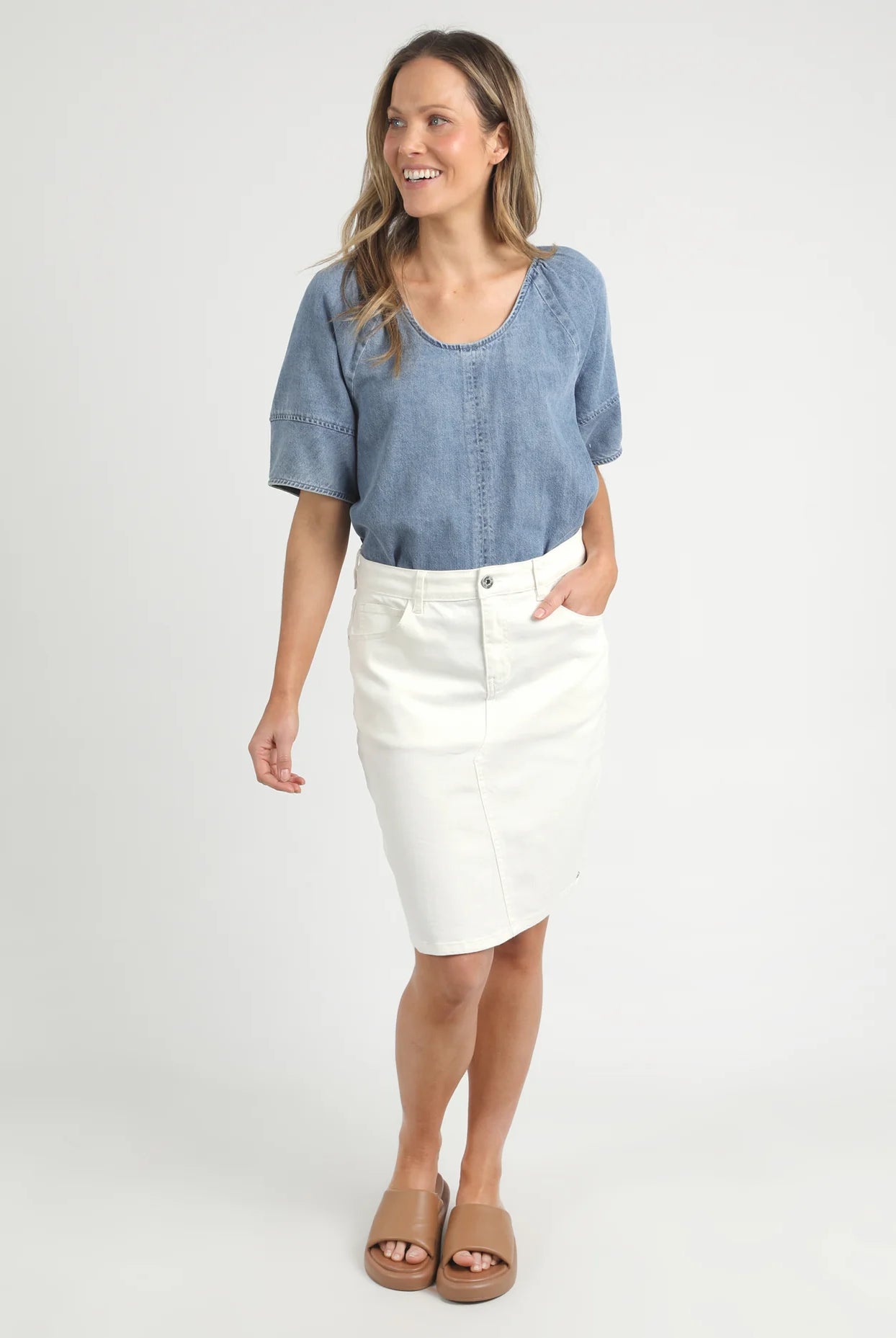 A woman modelling the Belle Vintage White Midi Denim Skirt by Elm