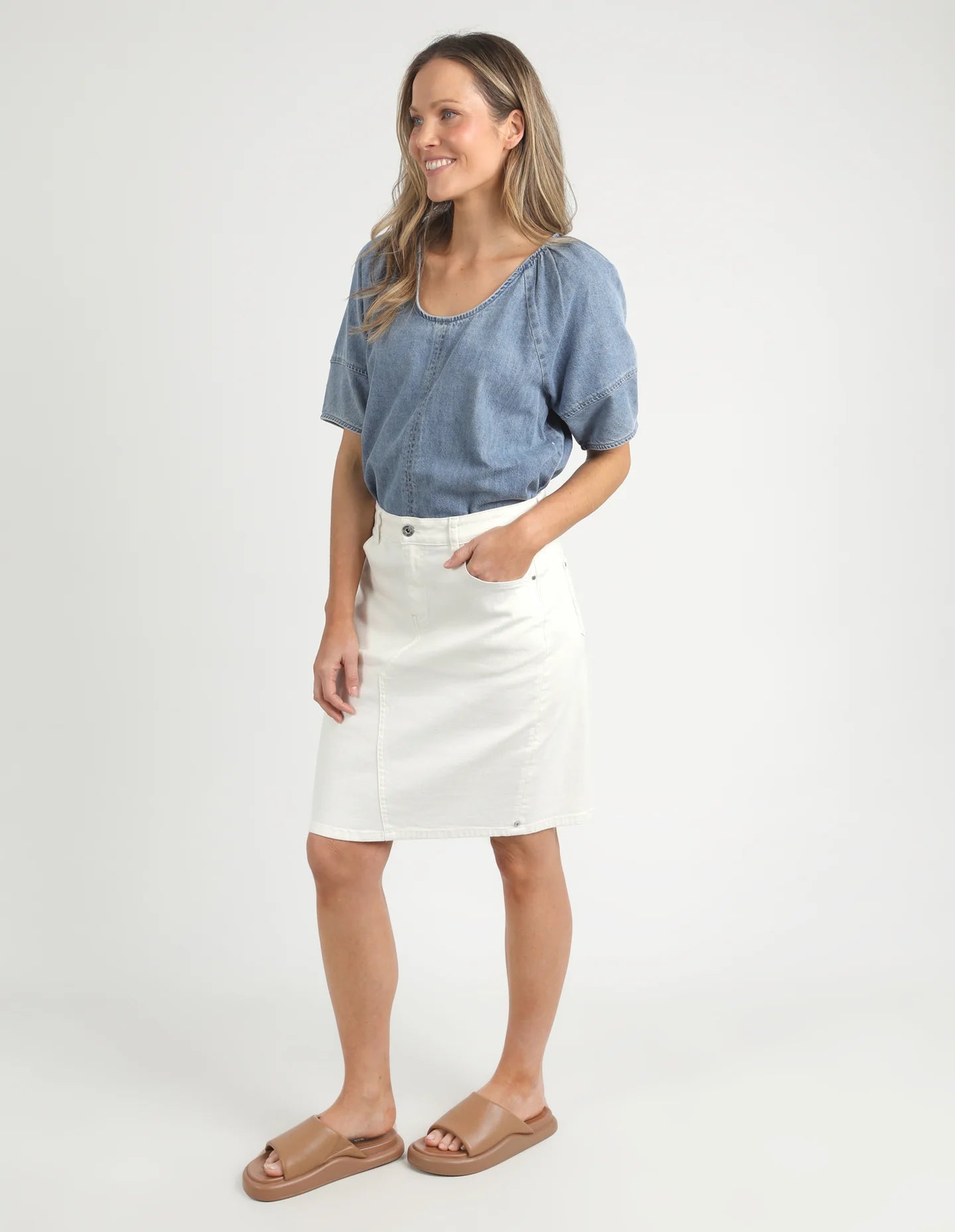A woman modelling the Belle Vintage White Midi Denim Skirt by Elm