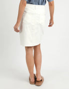 A woman modelling the Belle Vintage White Midi Denim Skirt by Elm