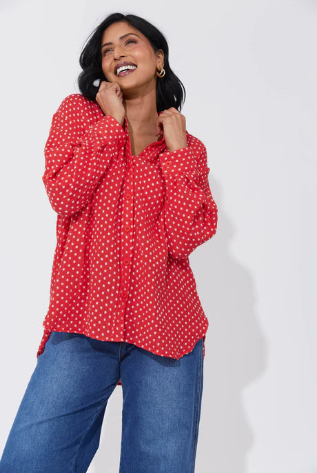 Vanuatu Shirt in Chilli with a relaxed fit, subtle square print, curved hem, and rolled tab sleeves showing a contrast colour block.