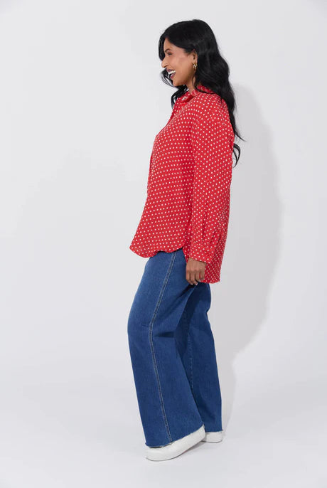 Vanuatu Shirt in Chilli with a relaxed fit, subtle square print, curved hem, and rolled tab sleeves showing a contrast colour block.