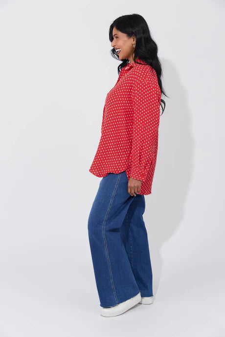 Vanuatu Shirt in Chilli with a relaxed fit, subtle square print, curved hem, and rolled tab sleeves showing a contrast colour block.