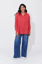 Vanuatu Shirt in Chilli with a relaxed fit, subtle square print, curved hem, and rolled tab sleeves showing a contrast colour block.