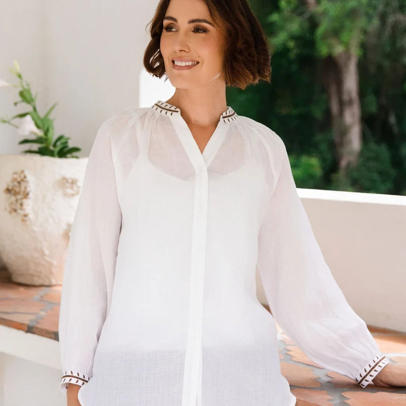 Ramie top featuring an embroidered collar and cuffs, notched neckline, gathered blouson sleeves and button-through front.