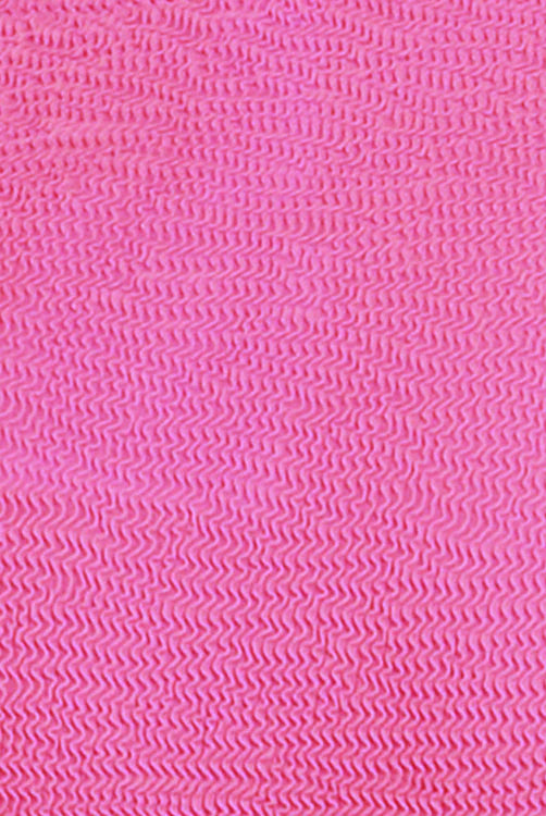 A bold flamingo-pink one-piece swimsuit with a low back, elongated leg line, Rio bottom coverage, and textured Italian fabric for a stylish, flattering fit.