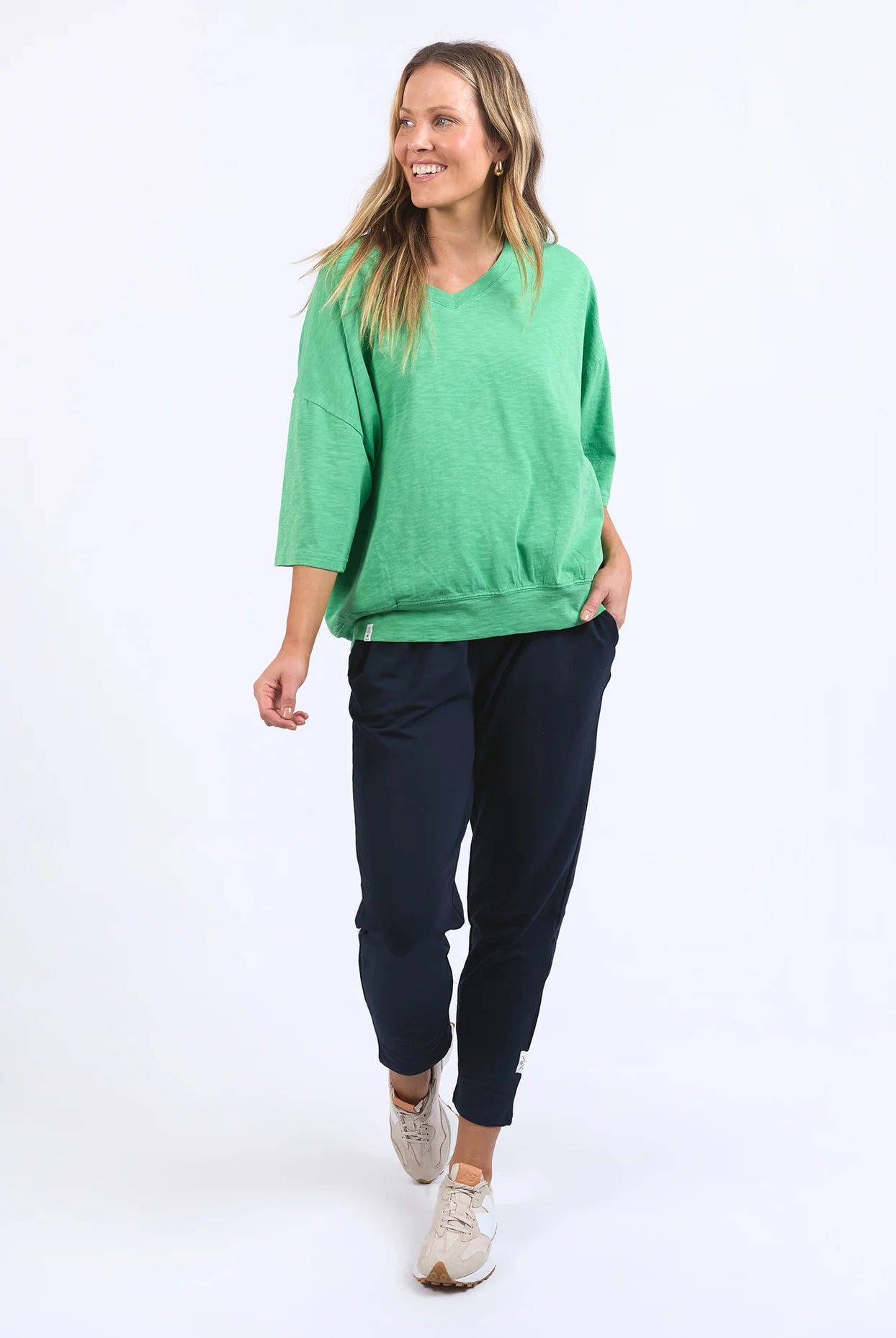 The Mazie Vee Neck in Greenbriar, a relaxed-fit cotton top with a spacious oversized design, features a flattering V-neckline, 3/4 length sleeves, and two front pockets, perfect for layering or casual wear