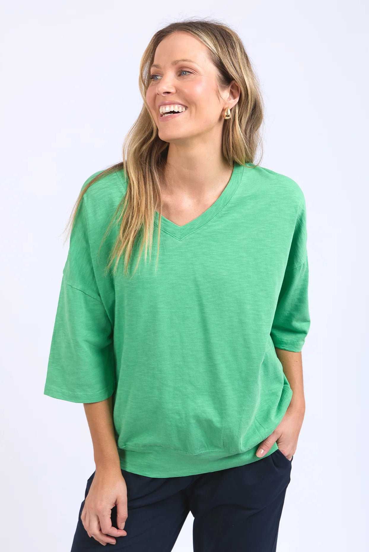 The Mazie Vee Neck in Greenbriar, a relaxed-fit cotton top with a spacious oversized design, features a flattering V-neckline, 3/4 length sleeves, and two front pockets, perfect for layering or casual wear