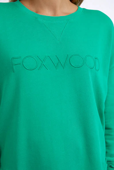 Foxwood Simplified Crew in bright green with round neck, raw edge details, and side splits for a relaxed, everyday look.