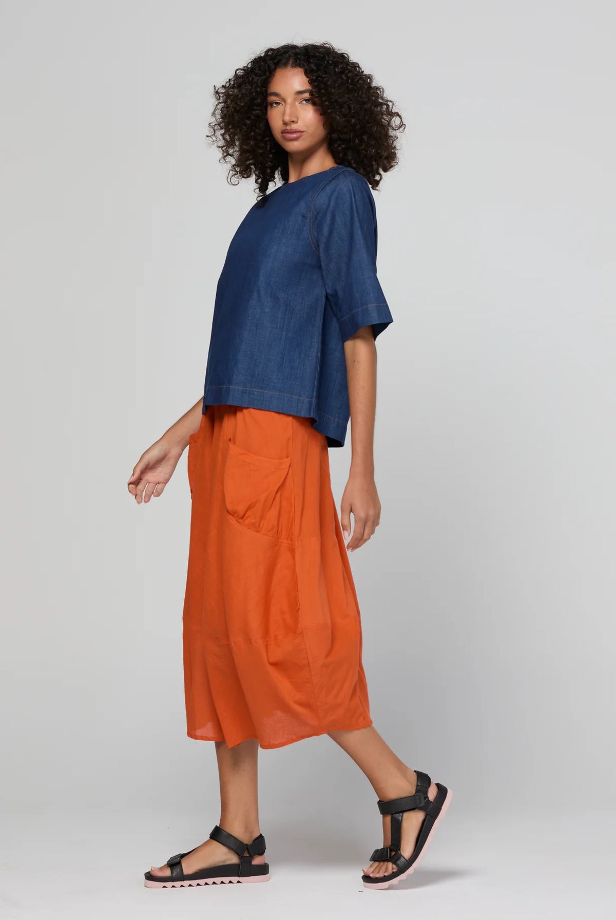 Guru Skirt in Rust, featuring a 3/4 length, stretch drawstring waistband, front and back pockets, full lining and black contrast stitching.