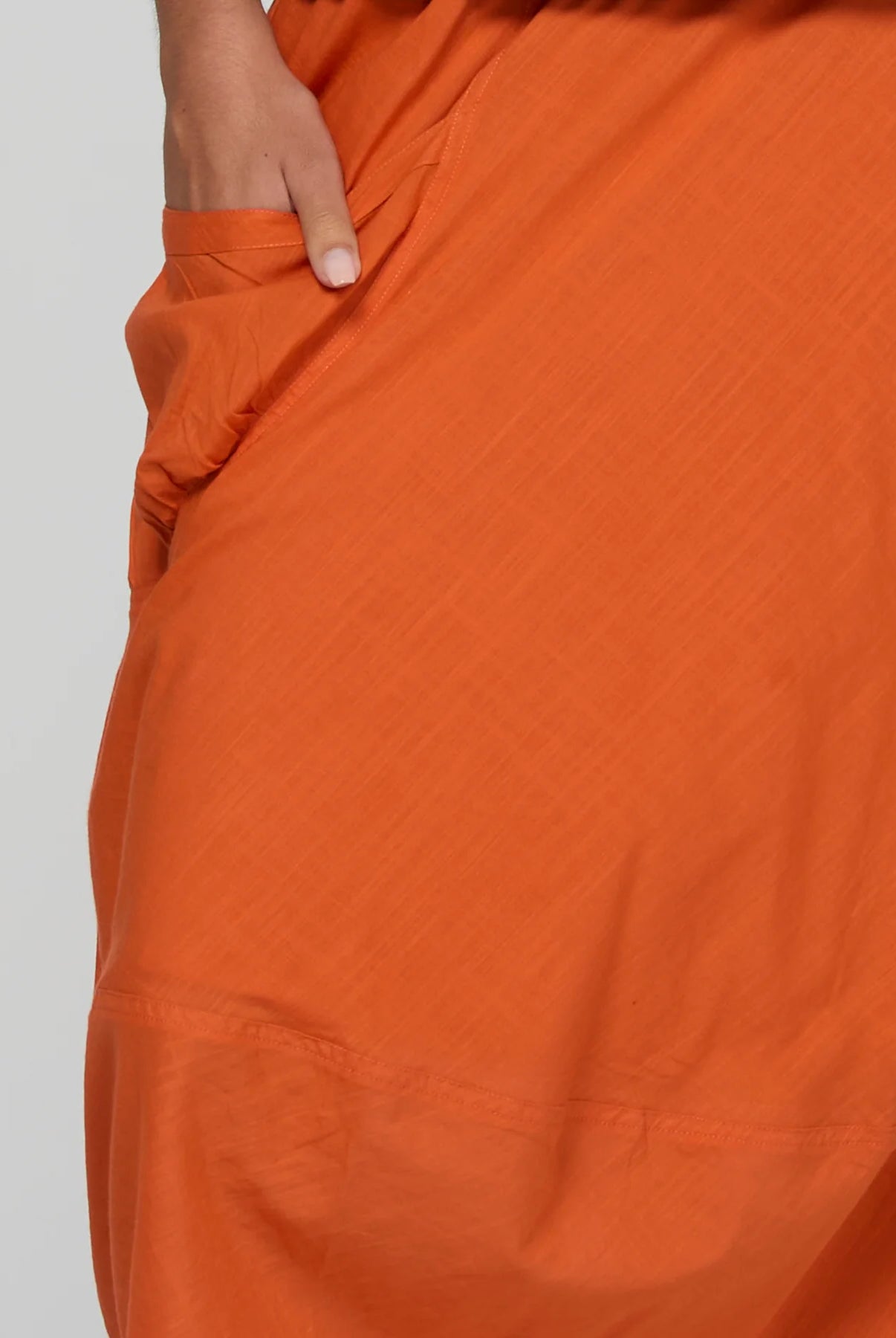 Guru Skirt in Rust, featuring a 3/4 length, stretch drawstring waistband, front and back pockets, full lining and black contrast stitching.