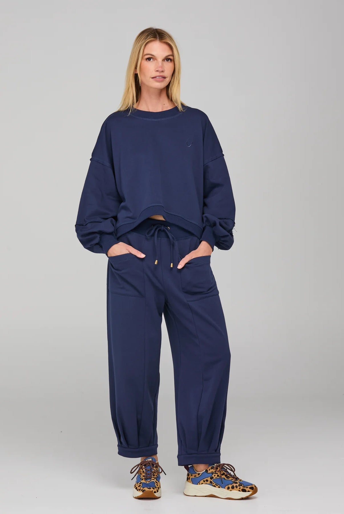 Boom Shankar Guru Track Pants in a relaxed fit with drawstring waistband, pleated front, contrast stitching, and back pocket SMILE logo