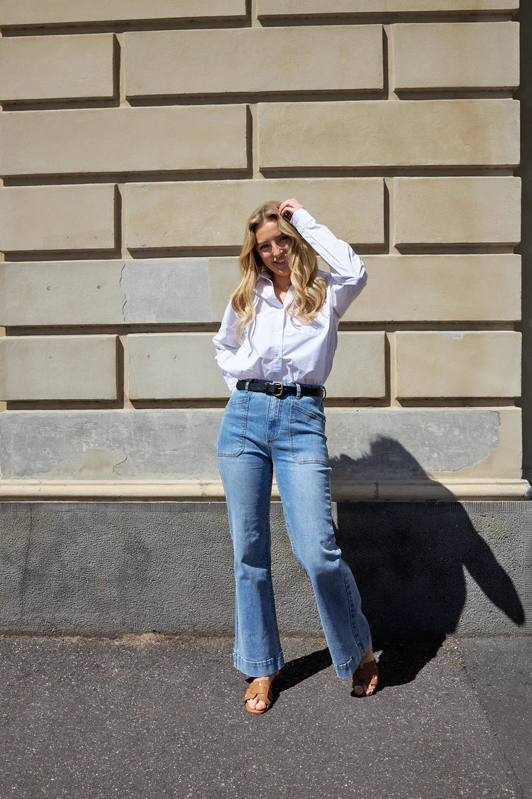 The Jayne Wide Leg Jean in vintage blue features a flattering high waist, super-stretch denim, front patch pockets, and a wide stitched hem.