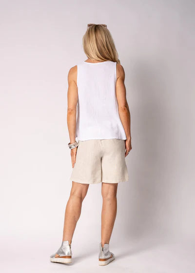 Justine Linen Top in breathable linen with draped false crossover front, V-shaped hemline, and delicate fringe detail along one side.