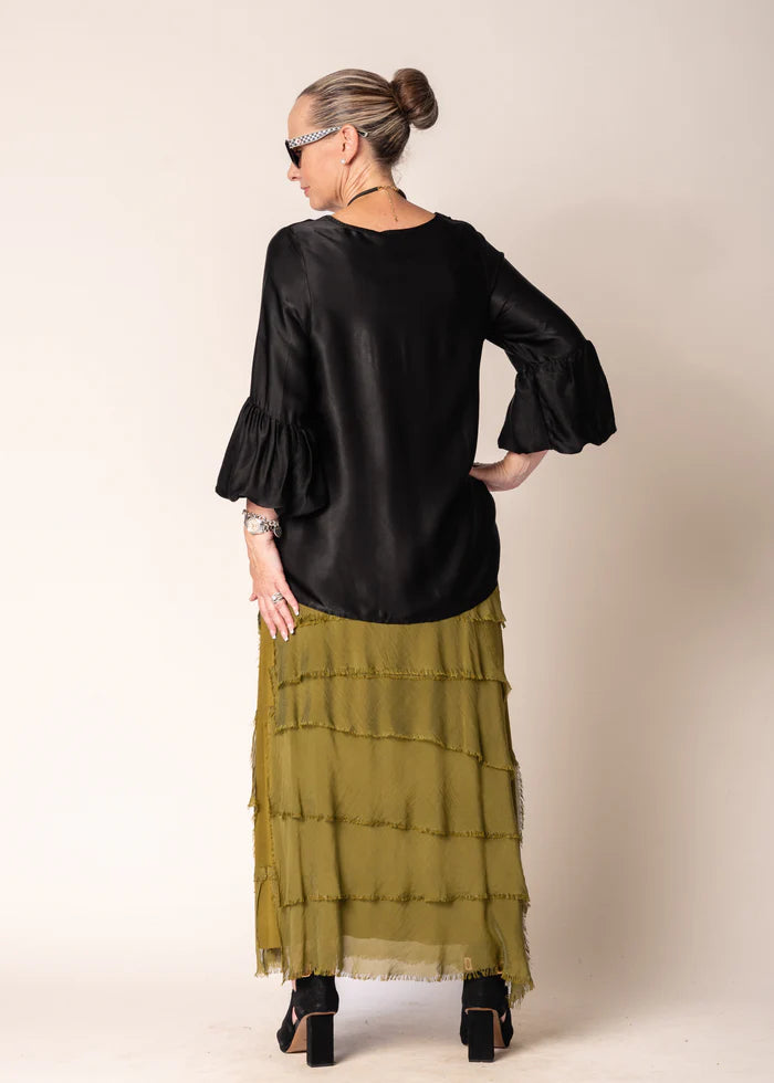 The Karley Satin Finish Top in Onyx features long sleeves with bell cuffs, a round neckline, and a split hemline, offering a sleek and modern silhouette.