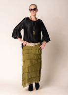 The Karley Satin Finish Top in Onyx features long sleeves with bell cuffs, a round neckline, and a split hemline, offering a sleek and modern silhouette.