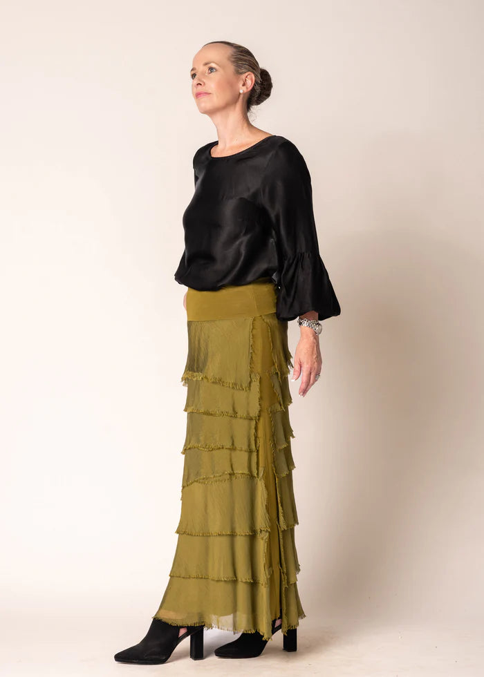 The Karley Satin Finish Top in Onyx features long sleeves with bell cuffs, a round neckline, and a split hemline, offering a sleek and modern silhouette.