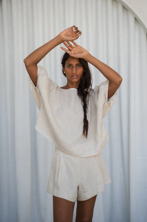 The Lily Pilly Tina Top in soft oatmeal linen is designed with a relaxed silhouette, lightweight feel, and natural textured weave.