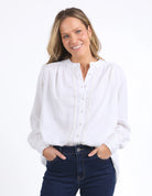 Long sleeve Marshmallow blouse with a front placket, button cuffs, and round collar, crafted from a soft linen blend for an elegant, easy-to-layer style.