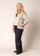 Marisol Top in Latte featuring a cropped V-neck design, asymmetrical hemline, and fringed detailing.