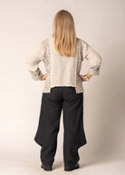 Marisol Top in Latte featuring a cropped V-neck design, asymmetrical hemline, and fringed detailing.