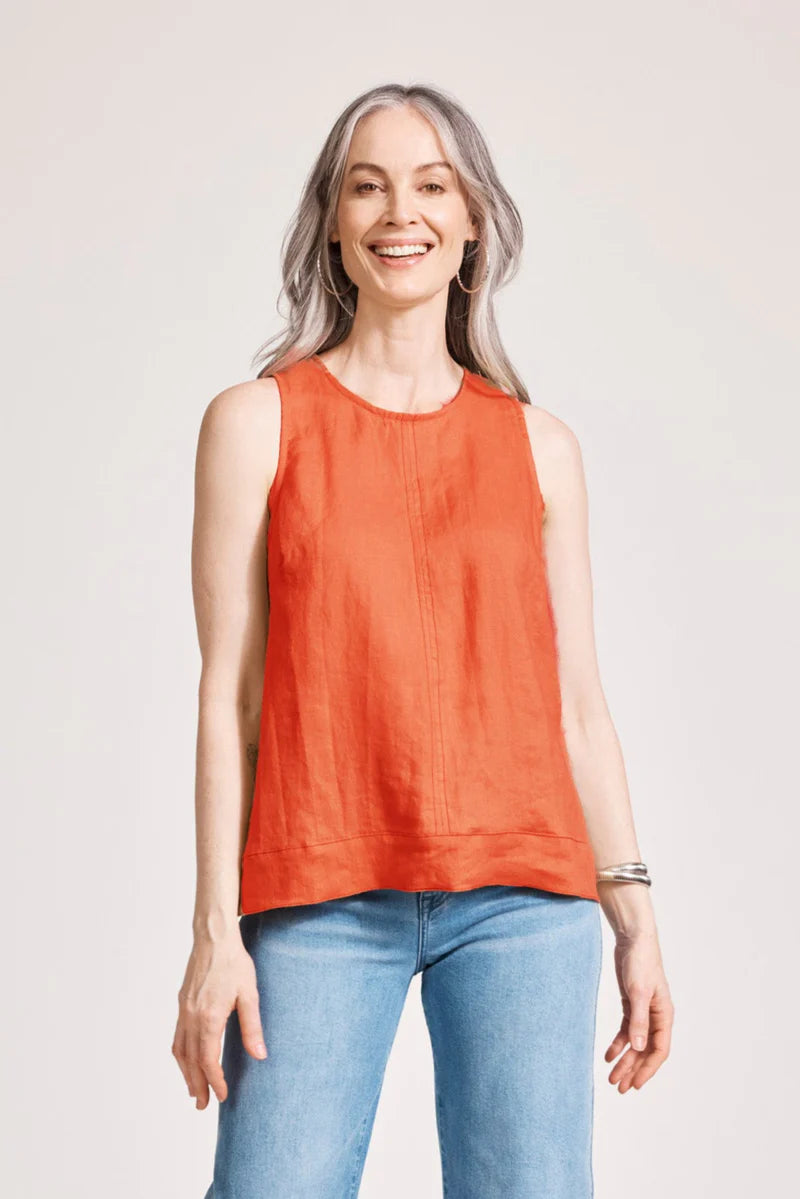 A relaxed, coral-coloured 100% linen tank top featuring exposed shoulders, contrast decorative topstitching, and a soft A-line silhouette. The design includes a wide cuffed hem and a button closure at the back neck, giving the lightweight, breathable top an effortlessly refined look