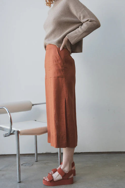 Nadi Linen Skirt in Cajun – A stylish, straight-cut linen skirt in a warm Cajun hue. Features oversized front pockets, side splits for ease of movement, and an elasticated back waistband for a comfortable, flattering fit.
