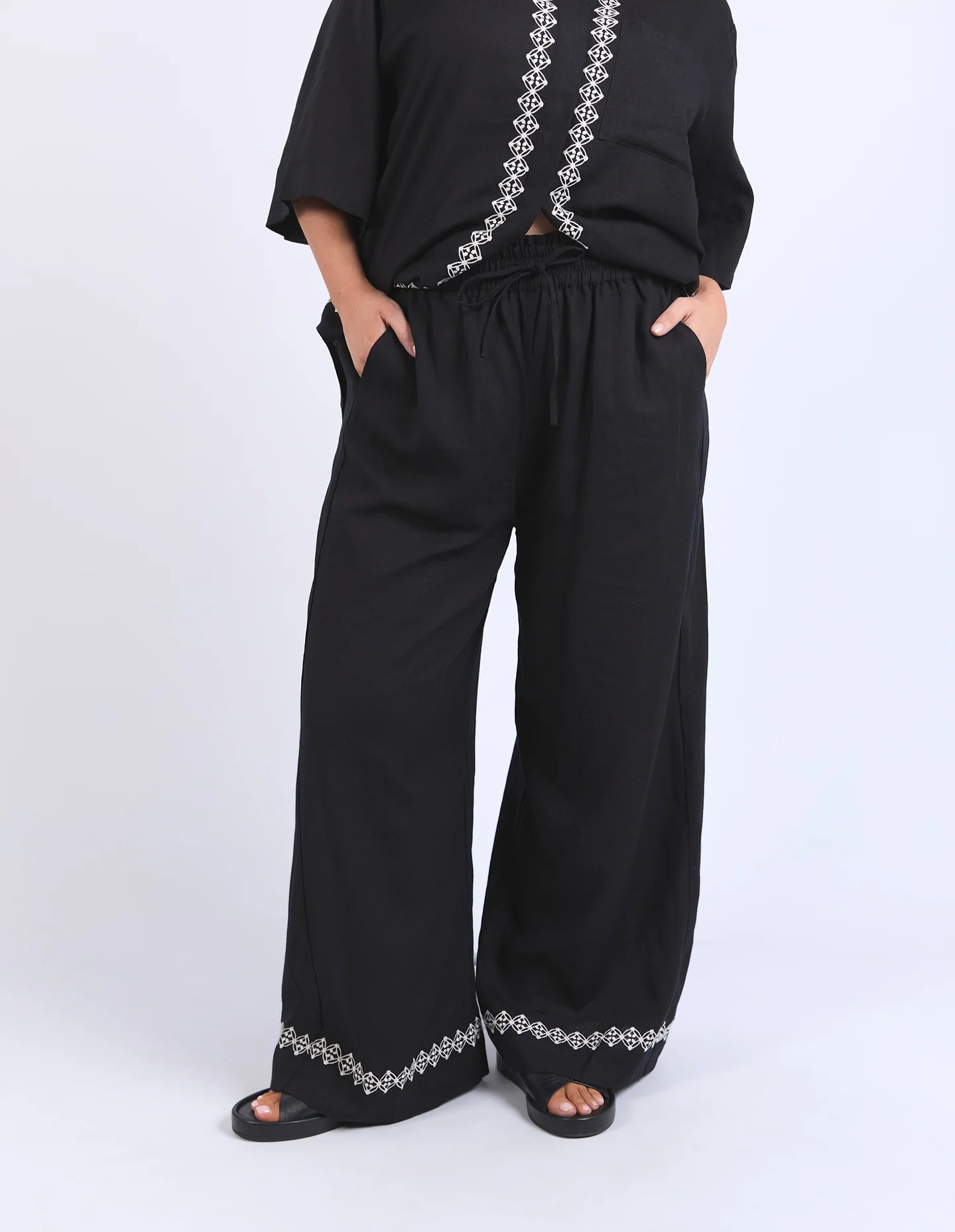 Black linen-viscose pants with an elastic waistband and embroidered hem, offering a relaxed and stylish fit.