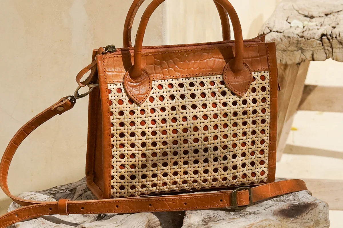 Prague Clutch in black and tan featuring natural rattan weaving with genuine leather accents in a sleek summer-ready design.