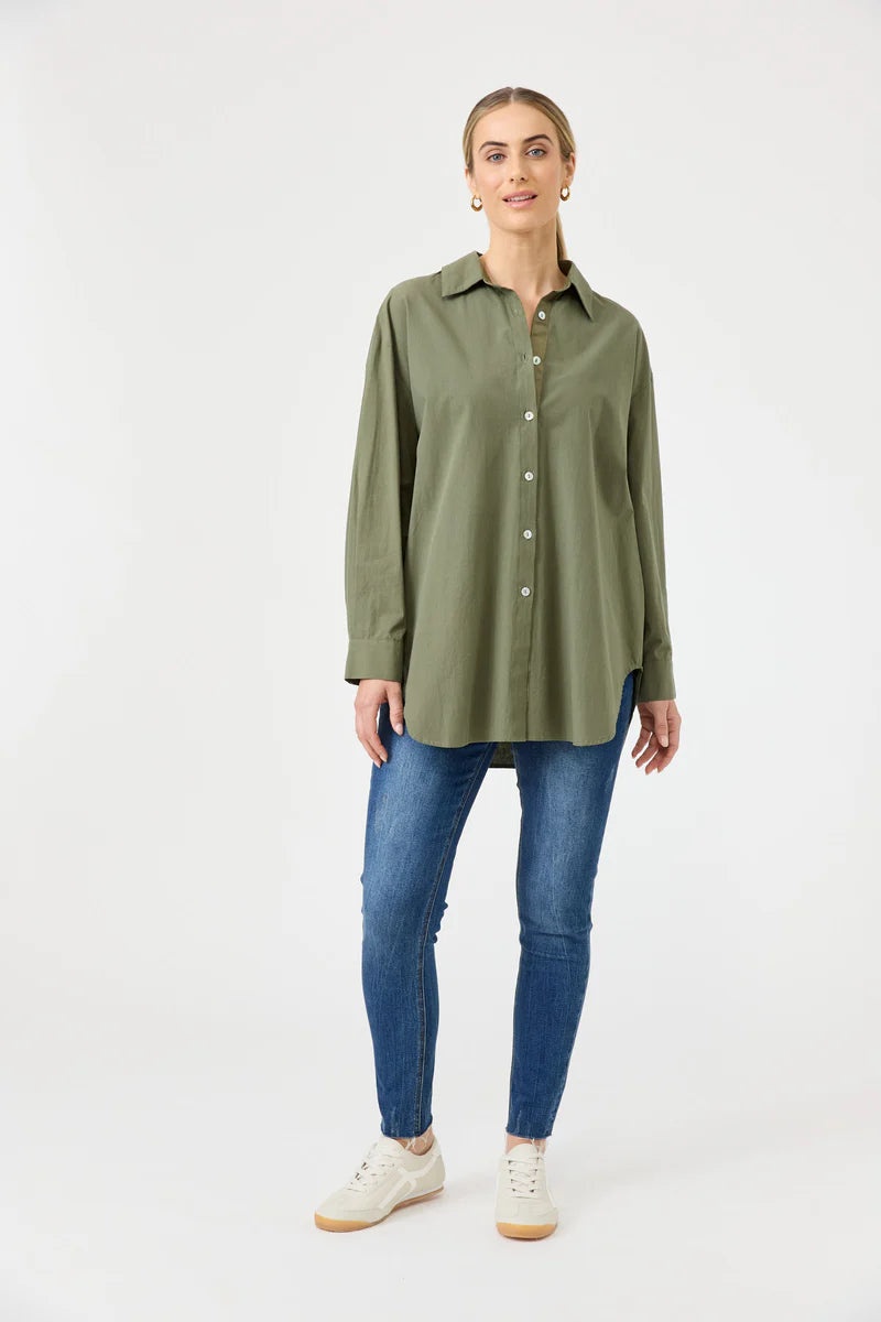 A khaki oversized button-down shirt made from soft cotton, featuring a relaxed fit, classic collar, and long sleeves, styled effortlessly for a casual yet polished look.