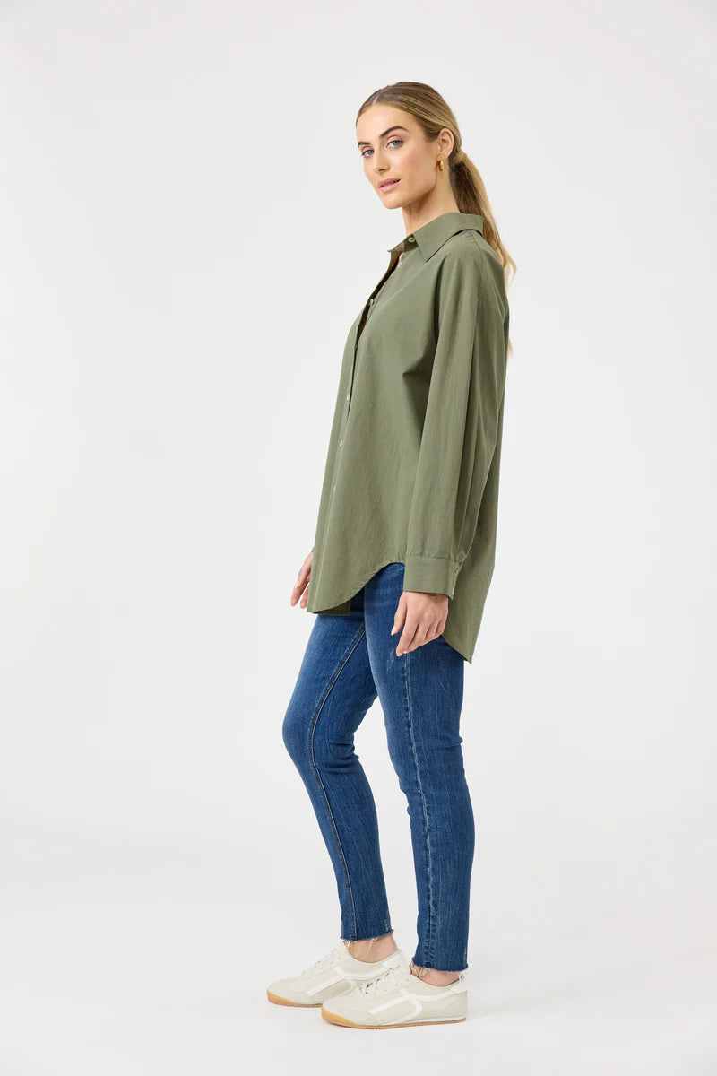 A khaki oversized button-down shirt made from soft cotton, featuring a relaxed fit, classic collar, and long sleeves, styled effortlessly for a casual yet polished look.