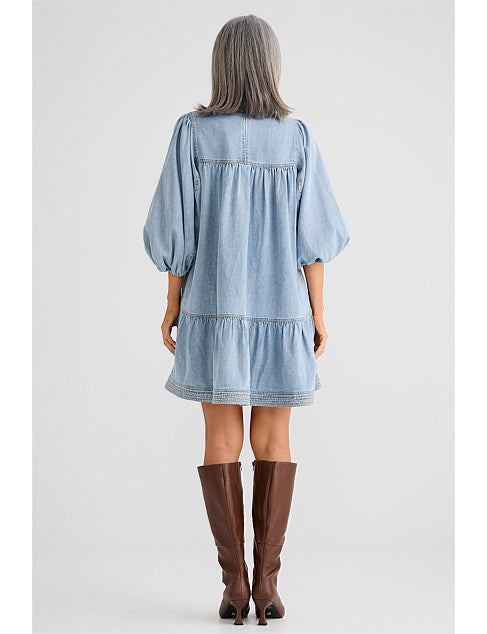 Mini dress featuring a mock neck collar with attached neck tie, 3/4 length balloon sleeves, contrast twin needle seam stitching, and a mini length silhouette.