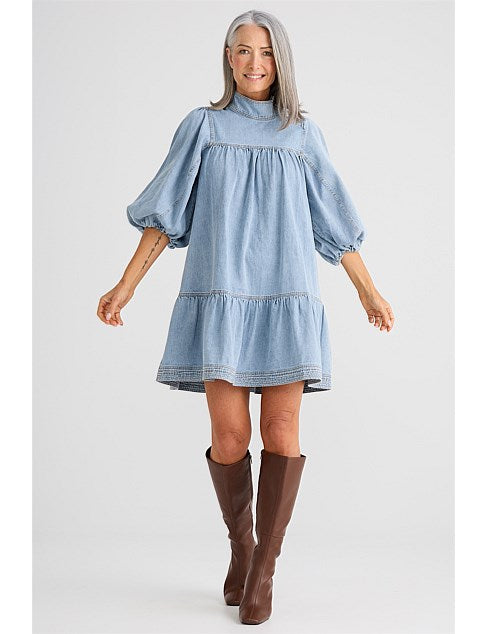 Mini dress featuring a mock neck collar with attached neck tie, 3/4 length balloon sleeves, contrast twin needle seam stitching, and a mini length silhouette.