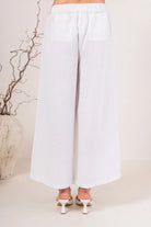 Palazzo linen pants featuring a relaxed wide-leg fit, high waist and shell button detailing down the side seam.