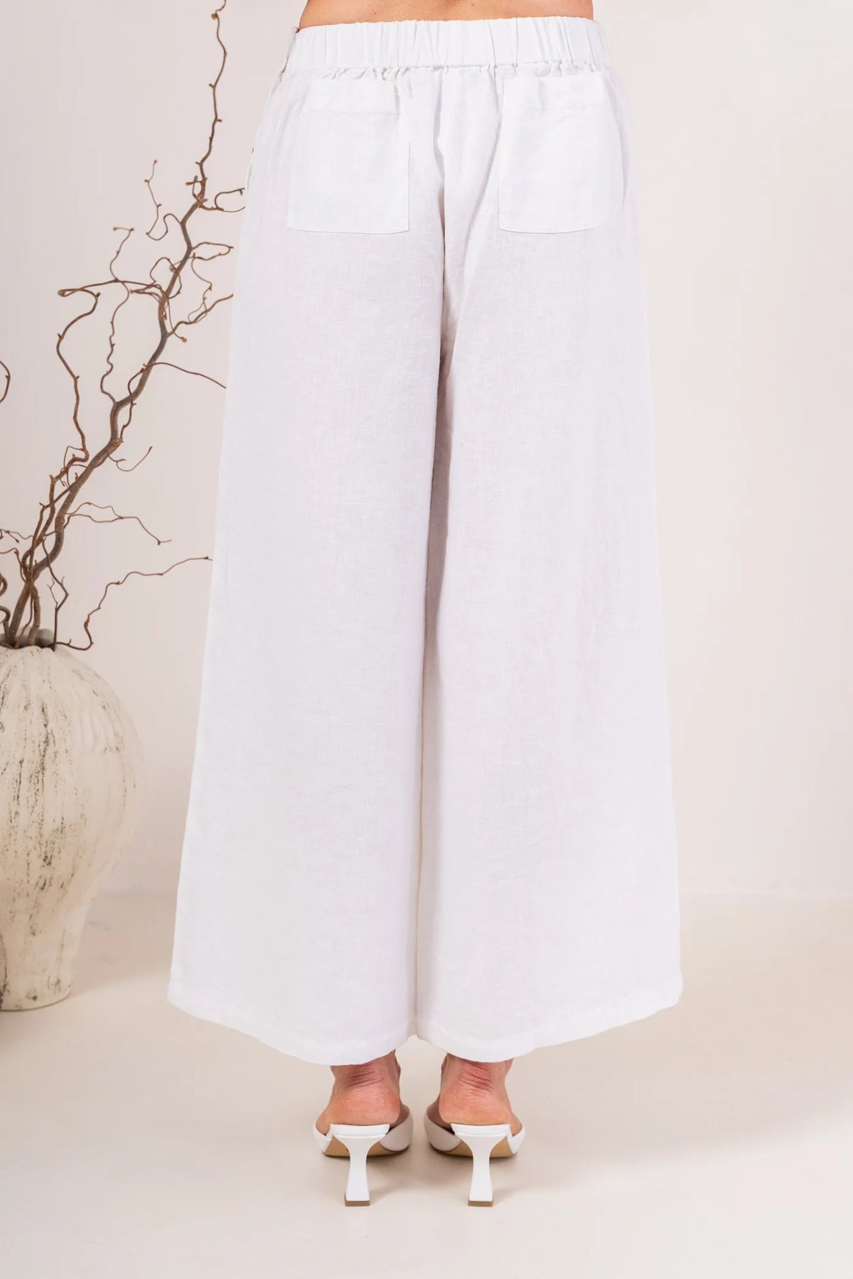 Palazzo linen pants featuring a relaxed wide-leg fit, high waist and shell button detailing down the side seam.