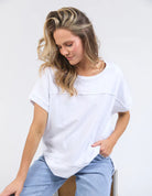 White 100% cotton Allison Tee with a relaxed fit, round neckline, design lines, and raw edge details, offering comfort and effortless style for everyday wear.