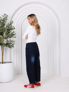 Leo barrel-leg jeans with a fitted waist, relaxed flared mid-leg, and tapered ankle, styled for a laid-back coastal look with a subtle Western-inspired edge.