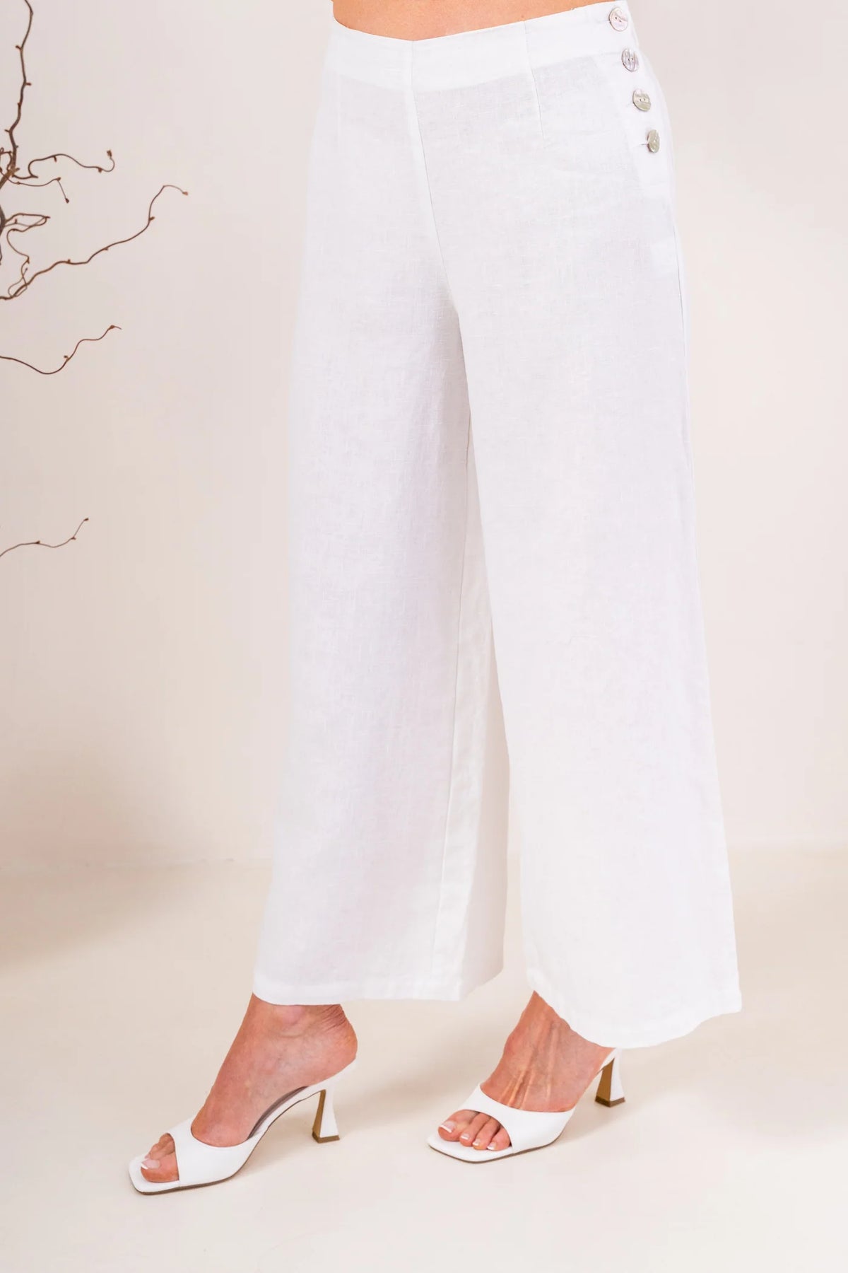 Palazzo linen pants featuring a relaxed wide-leg fit, high waist and shell button detailing down the side seam.