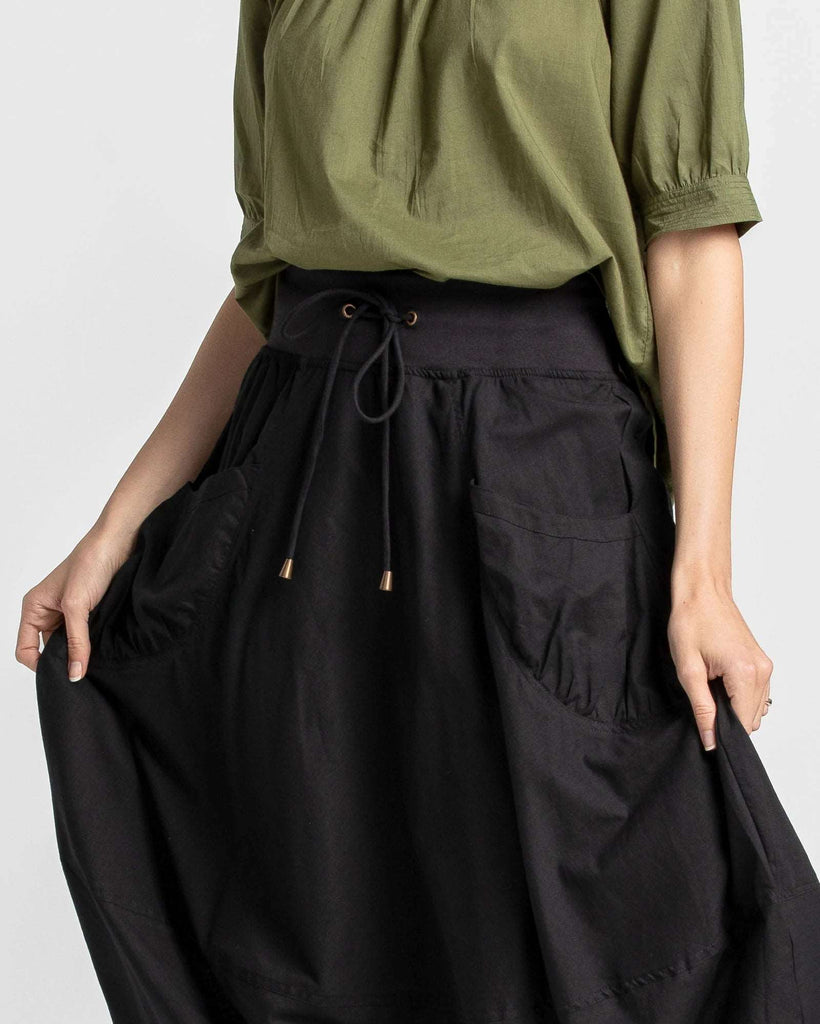 Our Guru skirt fits true to size. It has a fitted stretch waistband with a fuller loose-fitting skirt that is 3/4 length.