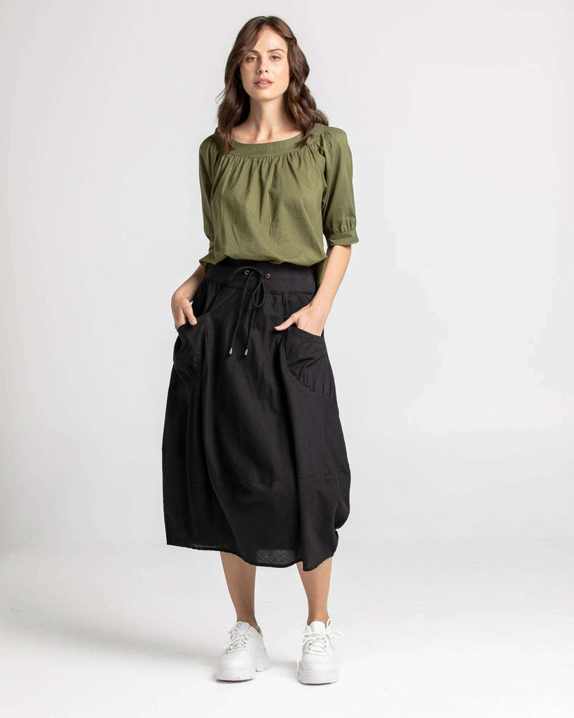Our Guru skirt fits true to size. It has a fitted stretch waistband with a fuller loose-fitting skirt that is 3/4 length.