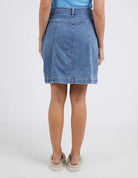 The Blue Eliza Denim Skirt by Elm is currently available at Rawspice Boutique.