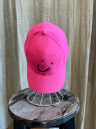 Smiley Cap in Pink with curved brim, adjustable back strap, and embroidered smiley face detail on the front.