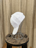Smiley Cap in White with curved brim, adjustable back strap, and embroidered smiley face detail on the front.