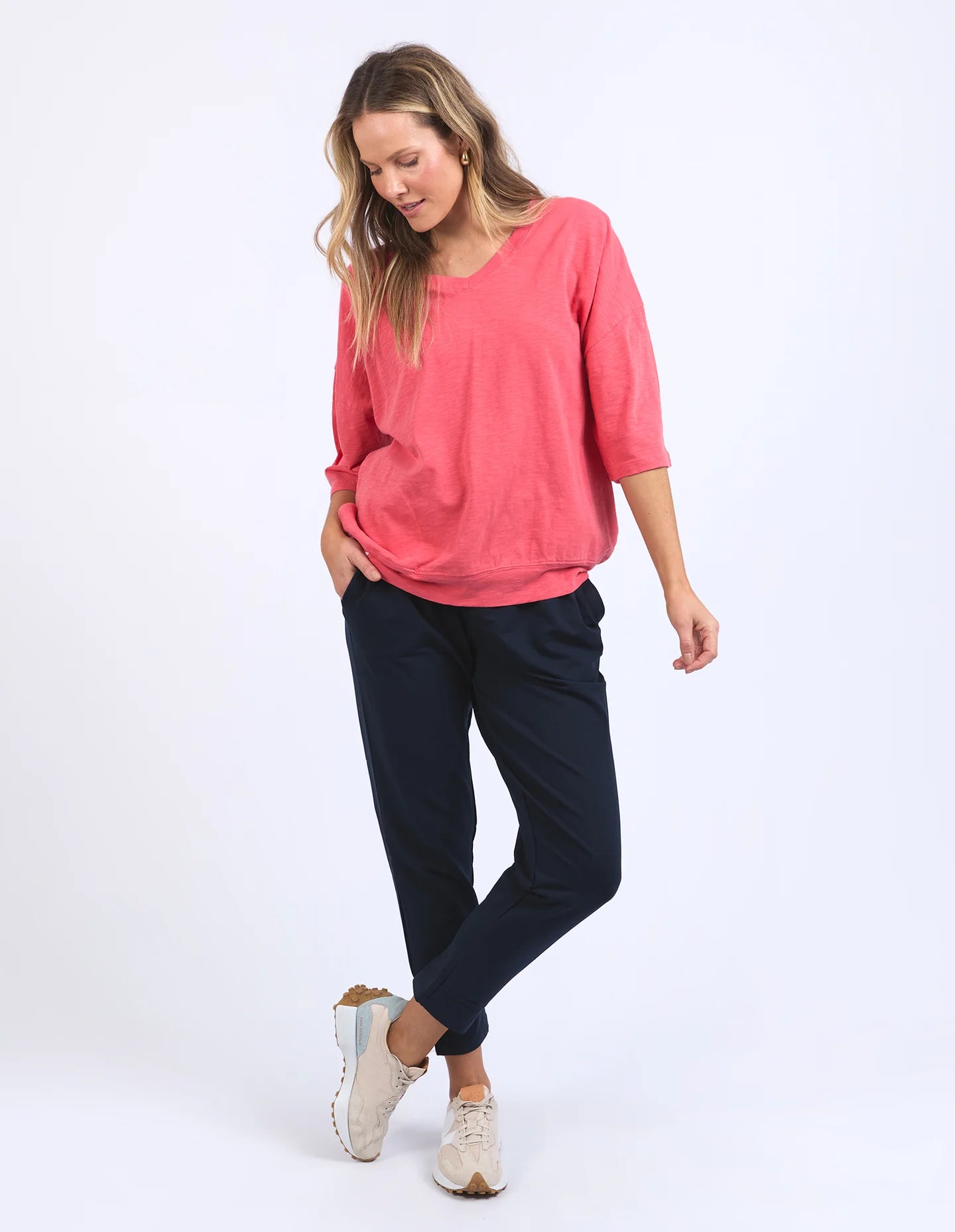 The Mazie Vee Neck in Watermelon Crush, a vibrant relaxed-fit cotton top, features a flattering V-neckline, 3/4 length sleeves, two front pockets, and a lightweight oversized design, ideal for layering or casual wear.