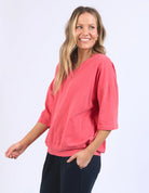 The Mazie Vee Neck in Watermelon Crush, a vibrant relaxed-fit cotton top, features a flattering V-neckline, 3/4 length sleeves, two front pockets, and a lightweight oversized design, ideal for layering or casual wear.