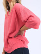 The Mazie Vee Neck in Watermelon Crush, a vibrant relaxed-fit cotton top, features a flattering V-neckline, 3/4 length sleeves, two front pockets, and a lightweight oversized design, ideal for layering or casual wear.